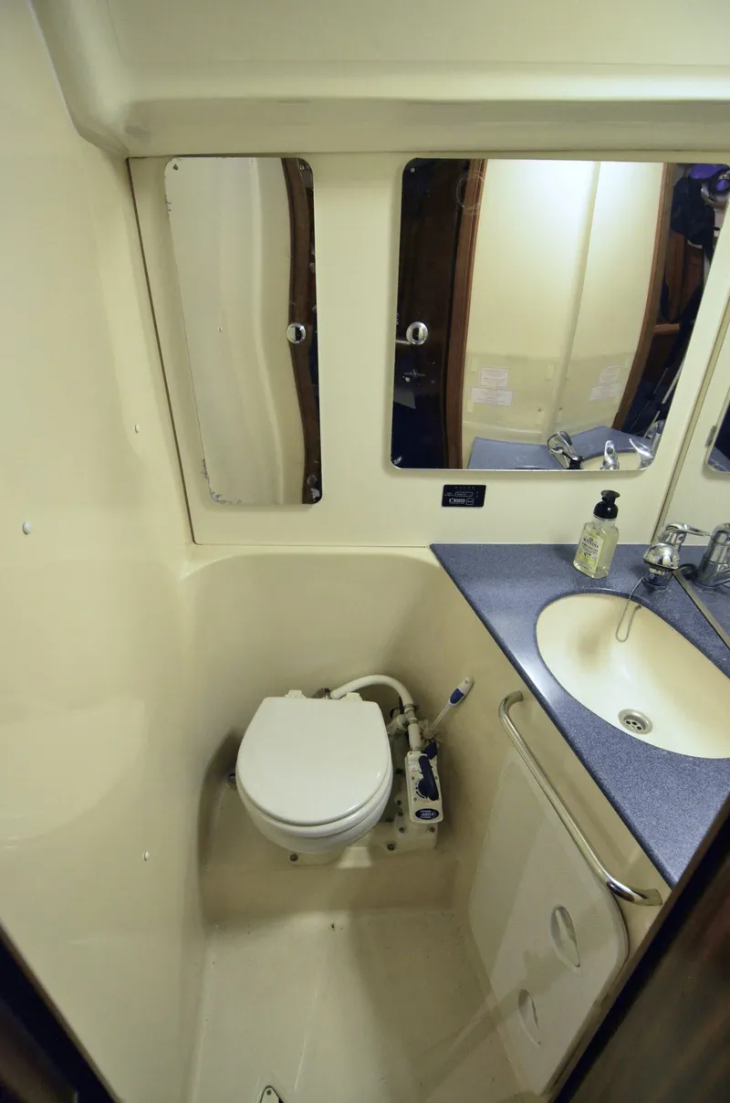 Slide: The Image of 2003 Bavaria 49 yacht bathroom with toilet, sink, and mirror. - 13