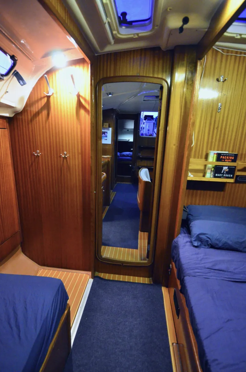 Slide: The Image of Interior of 2003 Bavaria 49 yacht cabin with wooden paneling and blue bedding. - 15