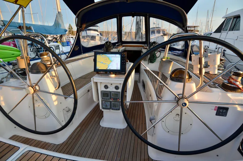 Slide: The Image of Cockpit of 2003 Bavaria 49 sailboat with dual steering wheels and navigation equipment. - 19