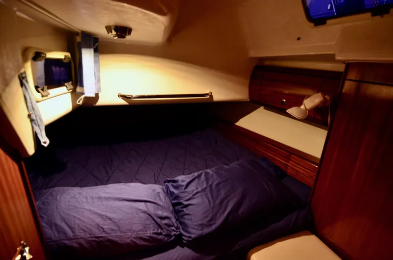 Slide: The Image of Cozy cabin interior of 2003 Bavaria 49 yacht with blue bedding and wooden accents. - 23