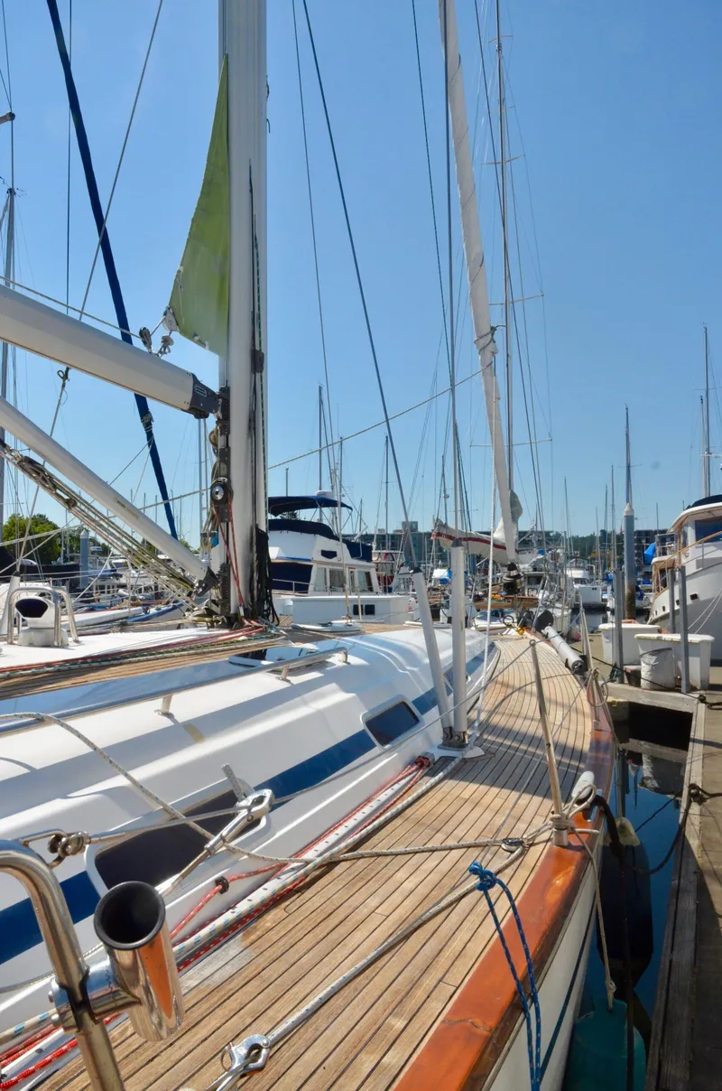 Slide: The Image of 2003 Bavaria 49 sailboat docked at a marina under clear blue skies. - 27