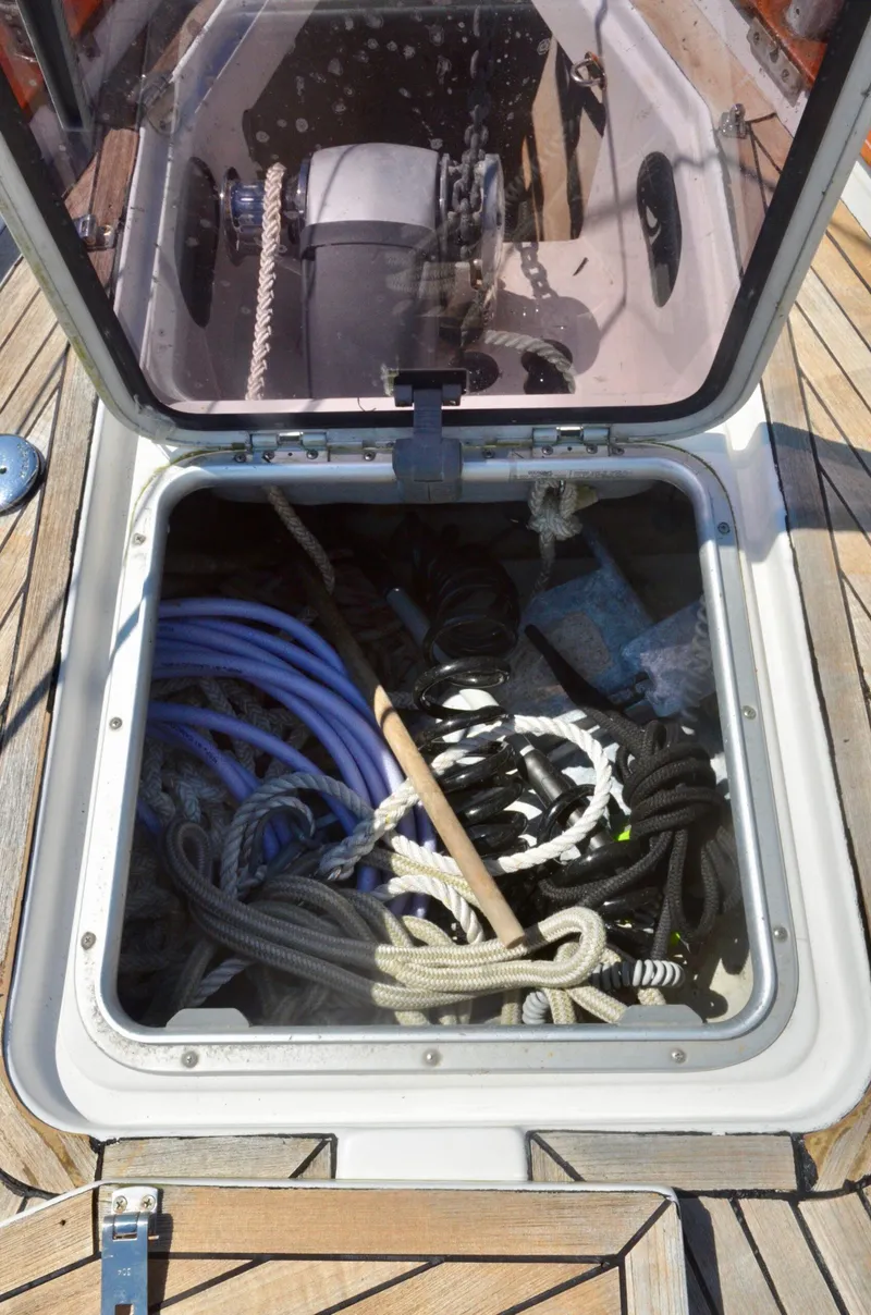 Slide: The Image of Open storage compartment on 2003 Bavaria 49 sailboat deck with ropes and equipment. - 30