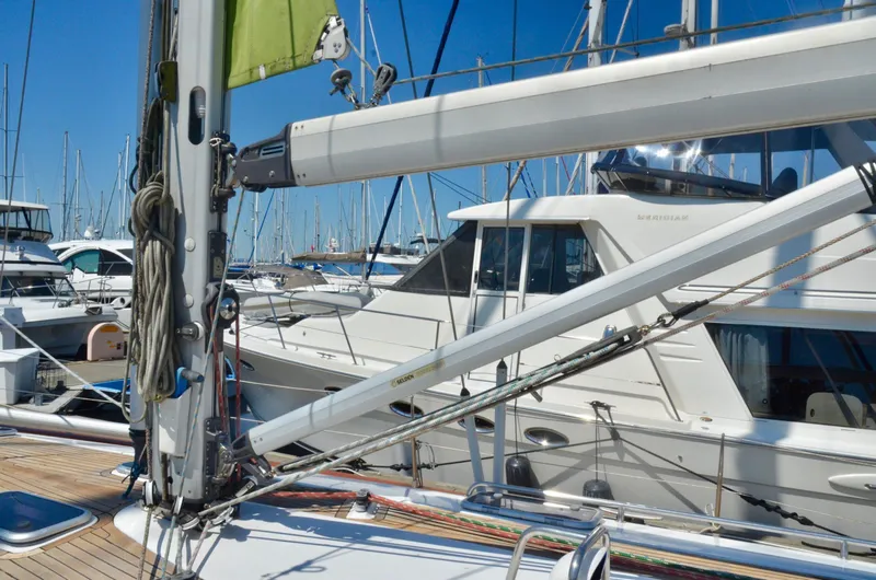 Slide: The Image of Sailboat Bavaria 49, 2003 model, docked in a marina with clear blue skies. - 37