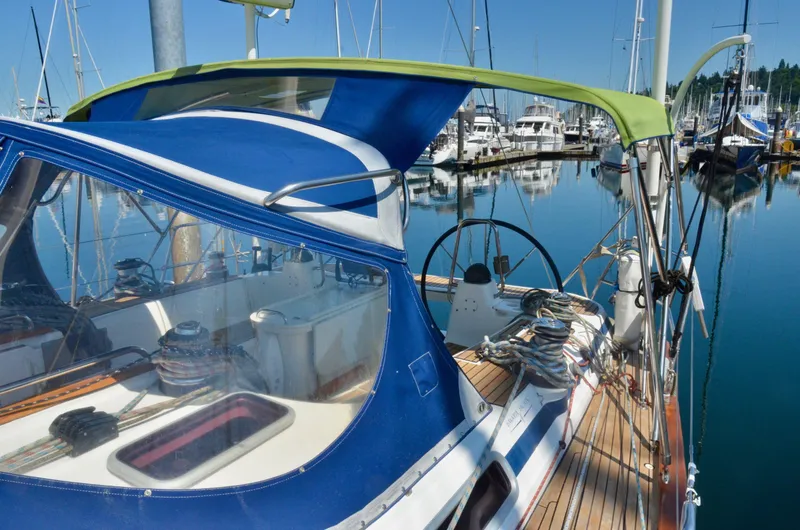 Slide: The Image of 2003 Bavaria 49 sailboat docked in a marina, featuring a blue and green canopy. - 40