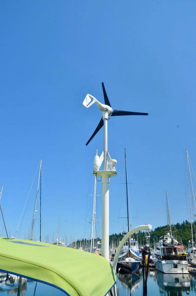 Slide: The Image of Wind turbine on Bavaria 49 yacht, 2003 model, docked in a marina under clear blue sky. - 41