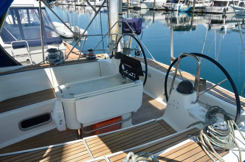 Slide: The Image of Cockpit of a 2003 Bavaria 49 yacht with dual steering wheels and teak decking. - 42