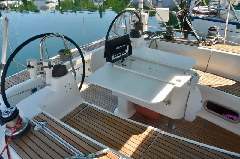 Slide: The Image of Cockpit of 2003 Bavaria 49 sailboat with dual steering wheels and wooden deck. - 49