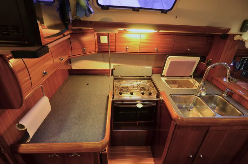 Slide: The Image of Interior of a 2003 Bavaria 49 yacht kitchen with wooden cabinetry and modern appliances. - 5