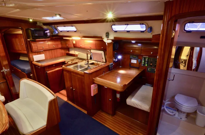 Slide: The Image of Luxurious interior of a 2003 Bavaria 49 yacht featuring a kitchen, dining area, and bathroom. - 6