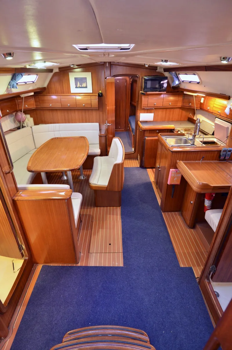 Slide: The Image of Interior of 2003 Bavaria 49 yacht with wooden furnishings and cozy dining area. - 7