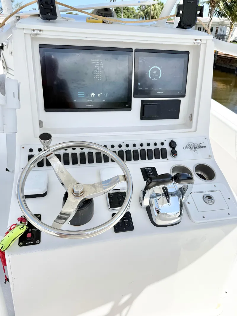 Slide: The Image of Control panel of 2021 Ocean Runner 2900 CC boat with steering wheel and digital displays. - 13