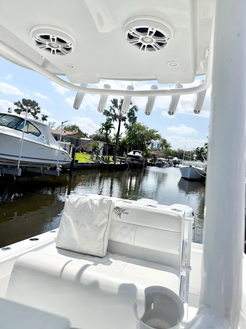 Slide: The Image of 2021 Ocean Runner 2900 CC boat docked in a scenic canal with palm trees. - 14