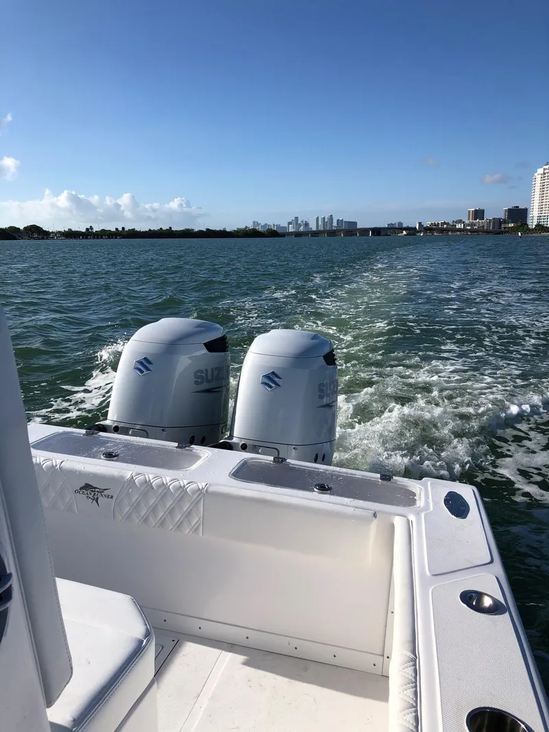 Slide: The Image of Ocean Runner 2900 CC boat with dual Suzuki engines cruising on a sunny day, 2021 model. - 17