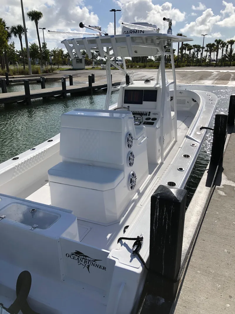 Slide: The Image of 2021 Ocean Runner 2900 CC boat docked, featuring Garmin electronics and spacious seating. - 5