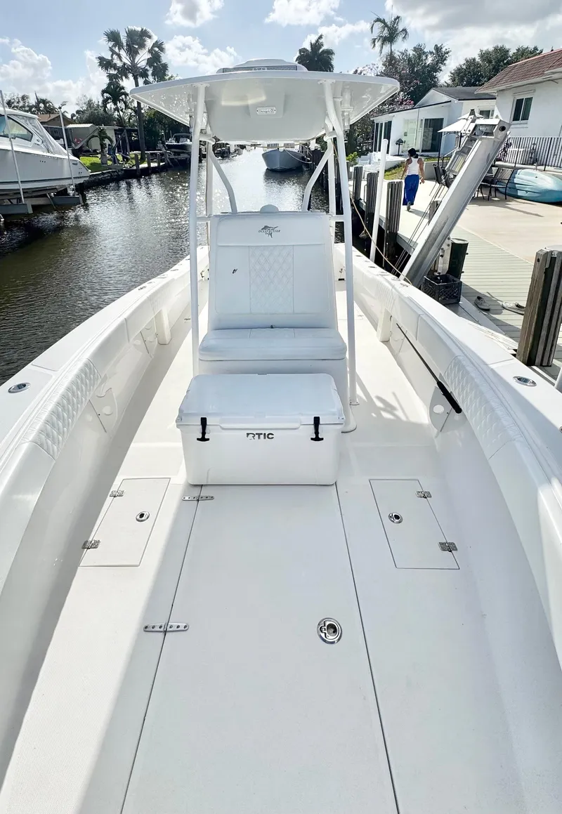 Slide: The Image of 2021 Ocean Runner 2900 CC boat with seating and RTIC cooler on deck, docked by a canal. - 8