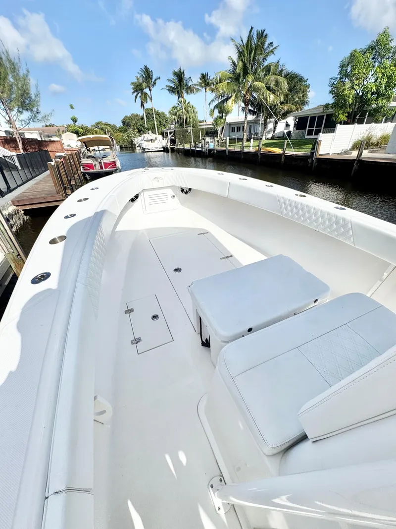 Slide: The Image of 2021 Ocean Runner 2900 CC boat docked by palm trees under a clear blue sky. - 9