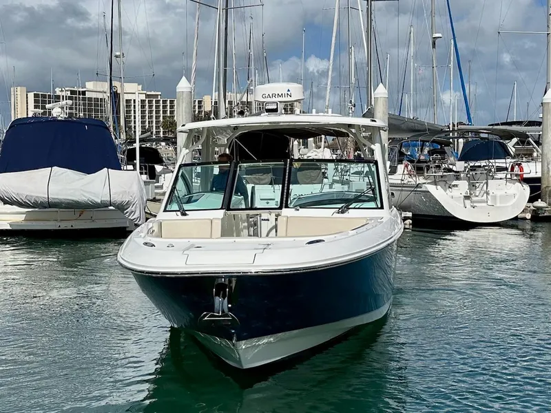Slide: The Image of 2016 Boston Whaler 320 Vantage docked in a marina, surrounded by other boats. - 2