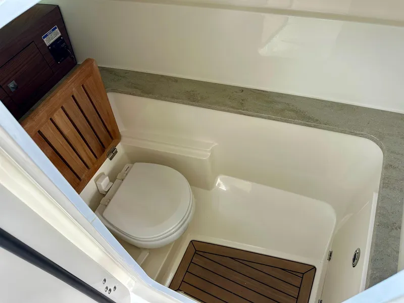 Slide: The Image of 2016 Boston Whaler 320 Vantage boat interior with toilet and wooden accents. - 20