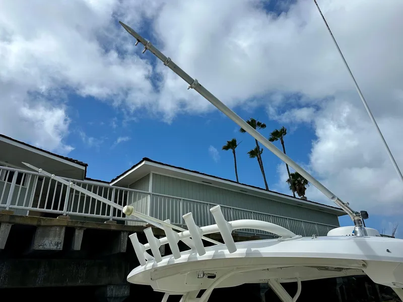Slide: The Image of 2016 Boston Whaler 320 Vantage boat with fishing rod holders, under a partly cloudy sky. - 24