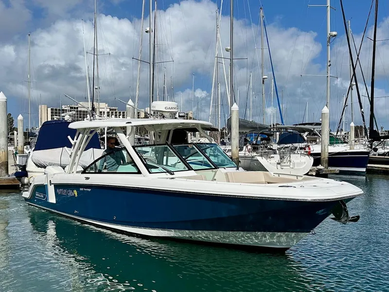 Slide: The Image of 2016 Boston Whaler 320 Vantage boat docked in a marina with sailboats. - 3