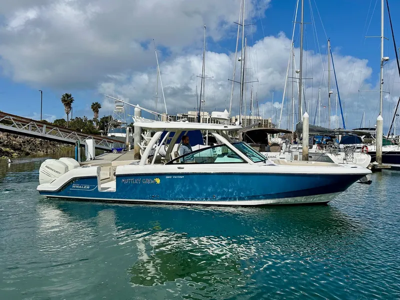 Slide: The Image of 2016 Boston Whaler 320 Vantage boat docked in a marina with clear blue water. - 4