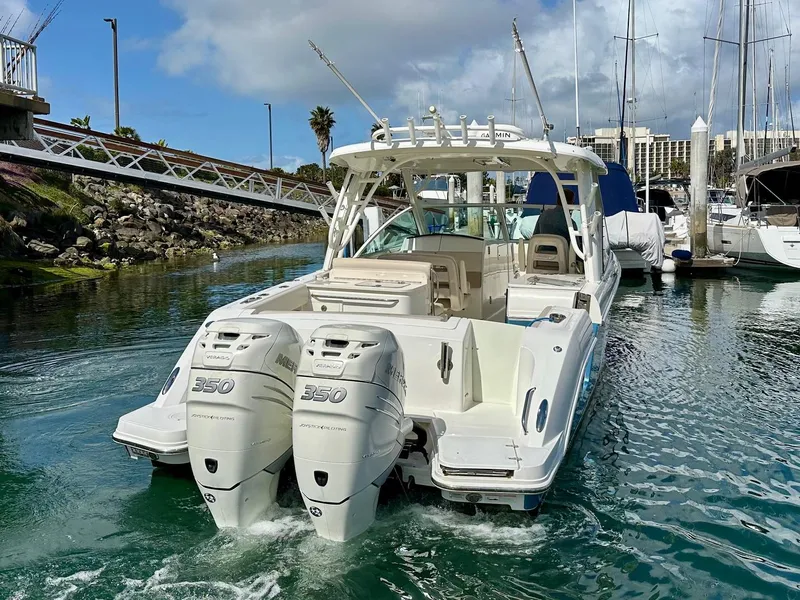 Slide: The Image of 2016 Boston Whaler 320 Vantage boat with twin 350 engines in a marina setting. - 6