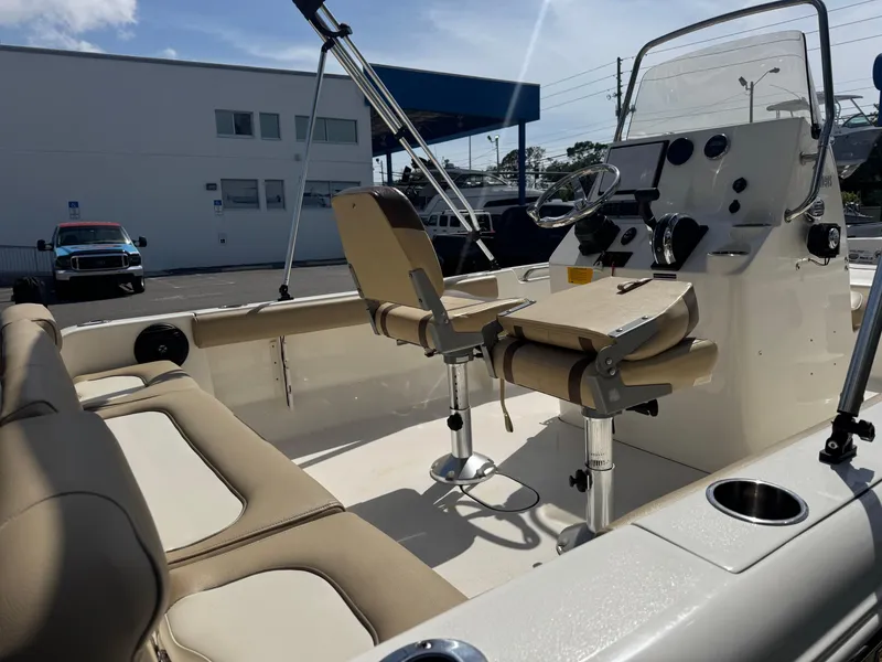 Slide: The Image of 2019 Key West 189 FS boat interior with beige seating and steering console. - 13
