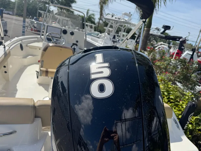 Slide: The Image of 2019 Key West 189 FS boat with 150 horsepower engine, parked outdoors. - 16