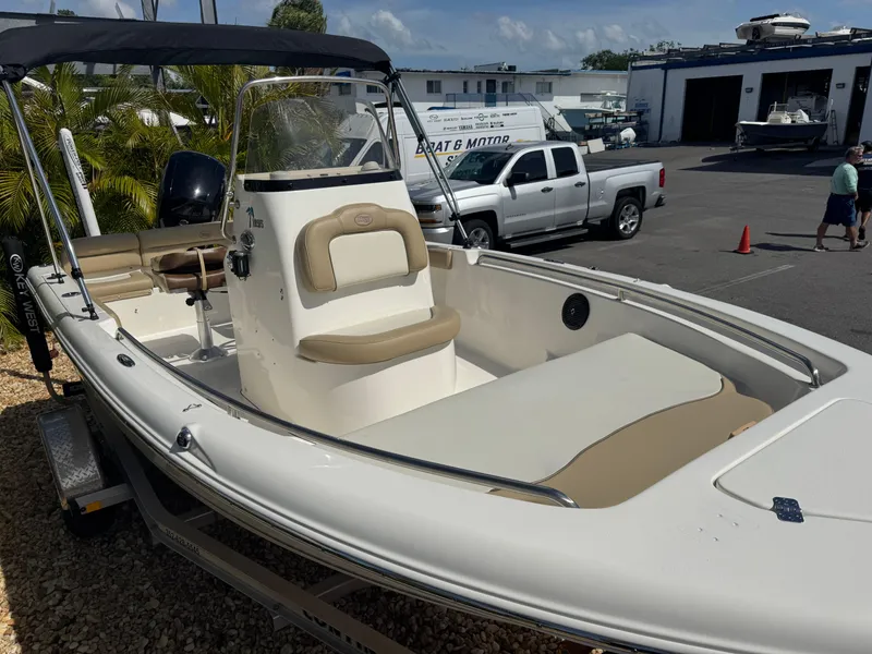 Slide: The Image of 2019 Key West 189 FS boat with seating, parked on a trailer in a marina. - 7