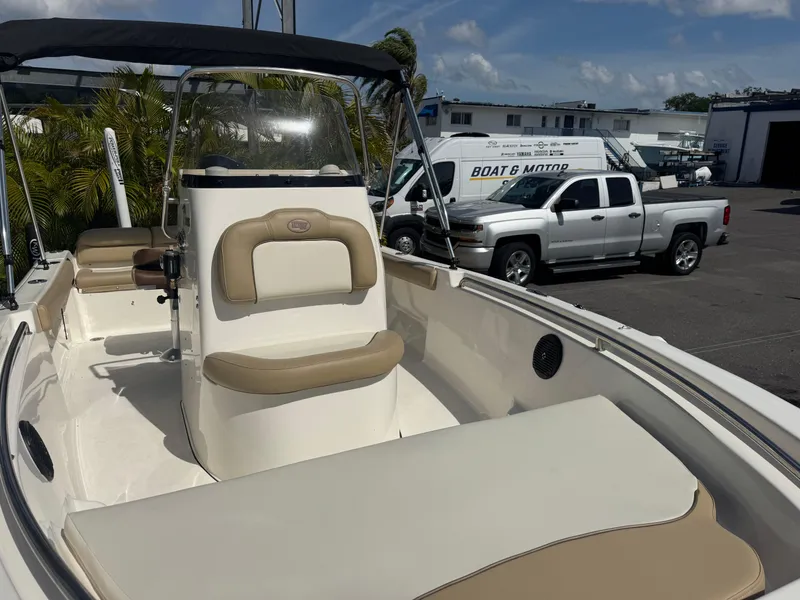 Slide: The Image of 2019 Key West 189 FS boat with beige seating, parked near trucks. - 8
