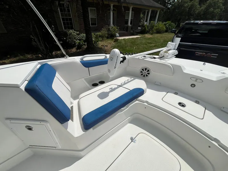 Slide: The Image of 2020 Tahoe 2150 CC boat interior with blue and white seating, parked near a house. - 25