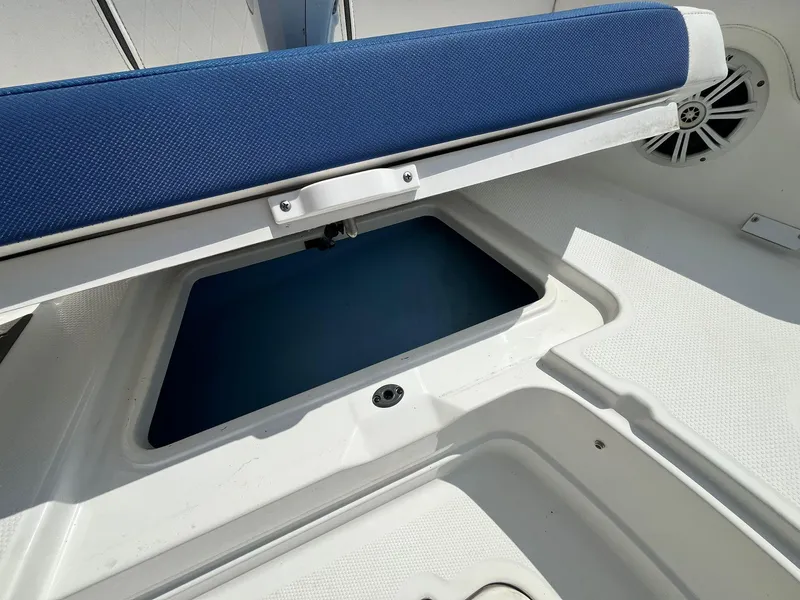 Slide: The Image of 2020 Tahoe 2150 CC boat storage compartment with blue cushioned seat. - 26