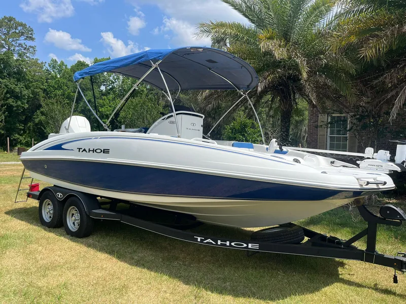 Slide: The Image of 2020 Tahoe 2150 CC boat on trailer with blue canopy, parked on grass. - 3