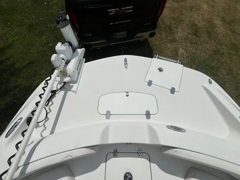 Slide: The Image of 2020 Tahoe 2150 CC boat deck with fishing equipment, parked near a GMC vehicle. - 31