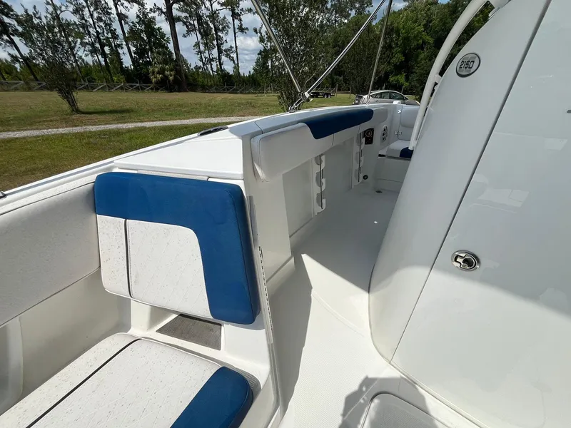 Slide: The Image of 2020 Tahoe 2150 CC boat interior with blue and white seating, outdoor setting. - 37