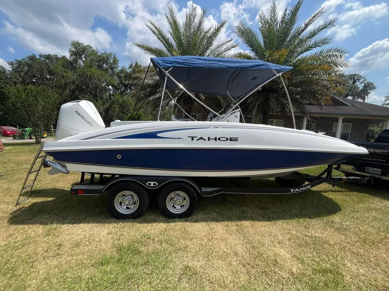 Slide: The Image of 2020 Tahoe 2150 CC boat on trailer with canopy, parked on grass under blue sky. - 5
