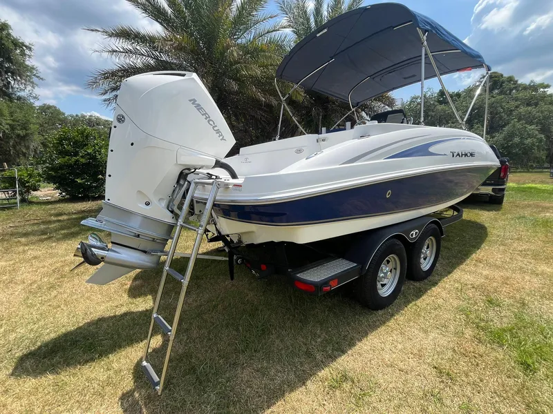 Slide: The Image of 2020 Tahoe 2150 CC boat with Mercury engine on trailer, parked on grass. - 6