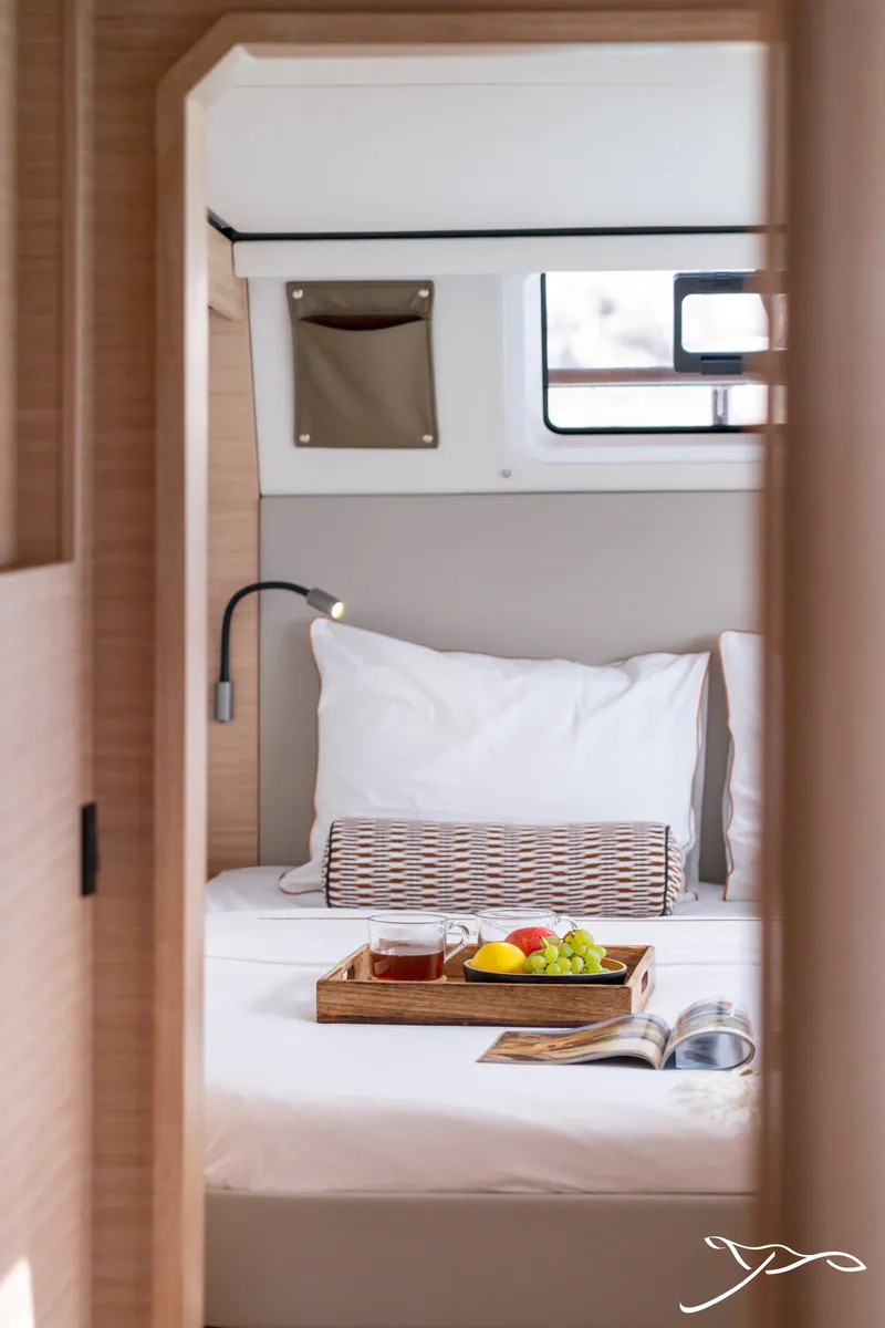 Slide: The Image of 2025 Nautitech 44 Open cabin with breakfast tray, cozy bedding, and natural light. - 44