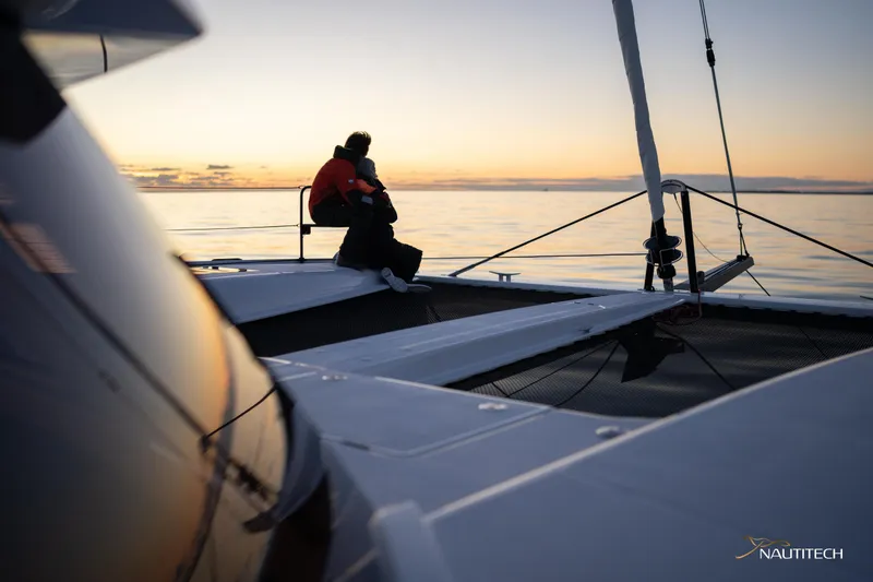 Slide: The Image of Couple enjoying sunset on Nautitech 48 Open catamaran, 2025 model, sailing on calm waters. - 15