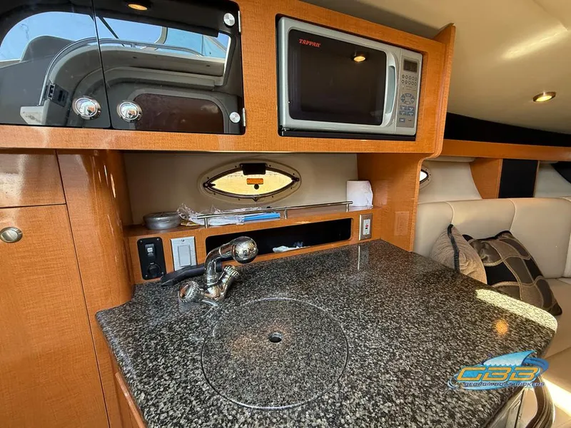 Slide: The Image of 2008 Chaparral Signature 250 interior with kitchenette, featuring granite countertop and microwave. - 27