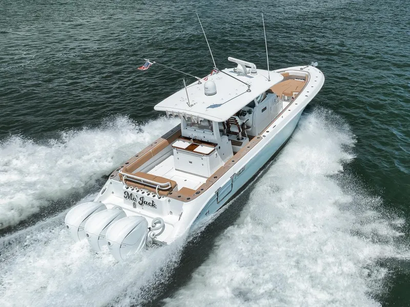 Slide: The Image of 2022 HCB Lujo boat cruising on water with triple outboard engines. - 12