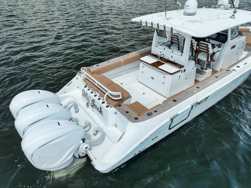 Slide: The Image of HCB Lujo 2022 boat with triple engines on water, featuring spacious deck and seating. - 18