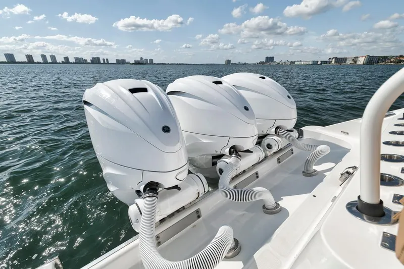 Slide: The Image of Triple outboard engines on a 2022 HCB Lujo boat, cruising on a sunny day. - 21