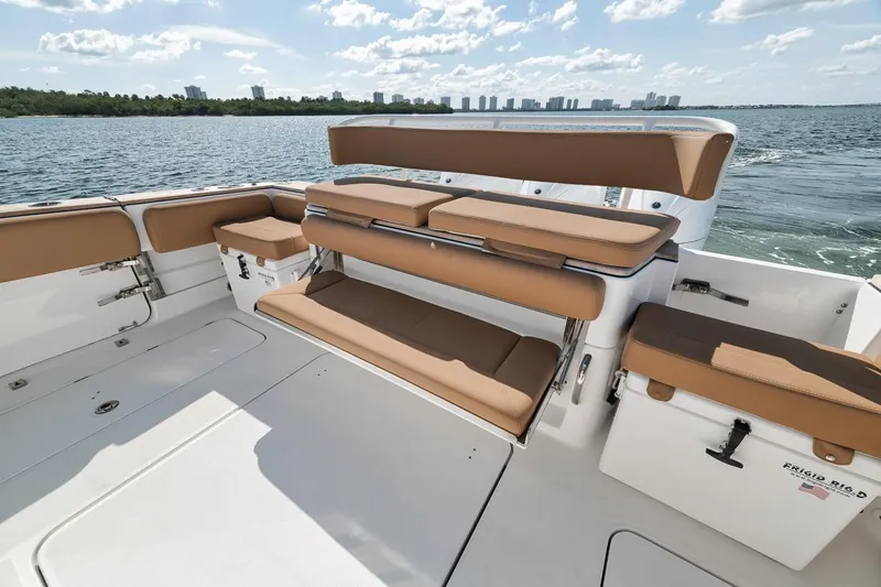 Slide: The Image of 2022 HCB Lujo boat interior with tan seating, ocean view, and city skyline. - 24