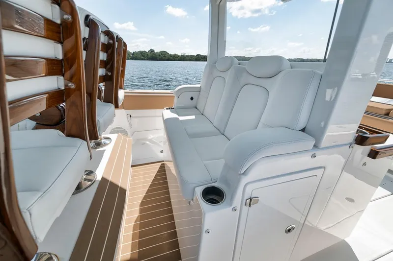Slide: The Image of Luxurious seating on 2022 HCB Lujo boat with elegant wood accents and water view. - 34