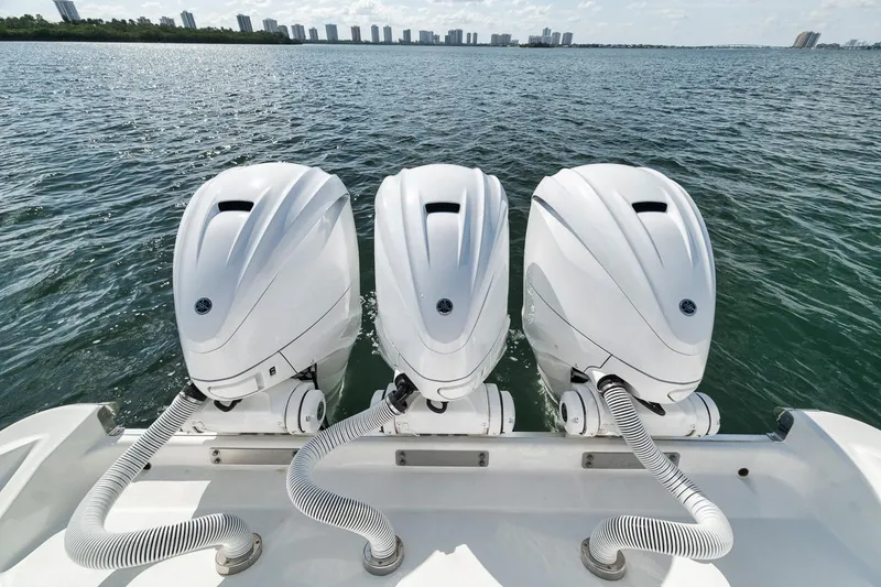 Slide: The Image of Triple outboard engines on a 2022 HCB Lujo boat, cruising on open water. - 20