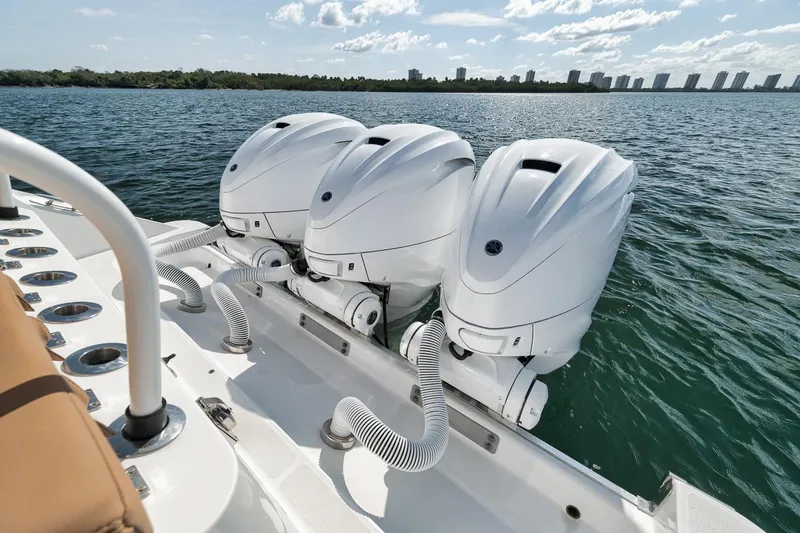 Slide: The Image of Triple outboard engines on a 2022 HCB Lujo boat, cruising on a sunny day. - 22
