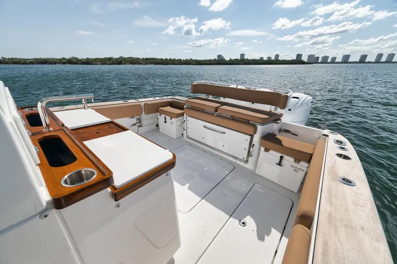 Slide: The Image of 2022 HCB Lujo boat deck with seating, overlooking calm waters and distant skyline. - 23