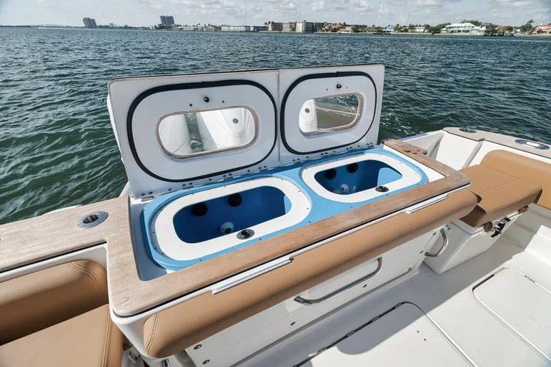 Slide: The Image of 2022 HCB Lujo boat with dual livewells on deck, ocean view in background. - 25