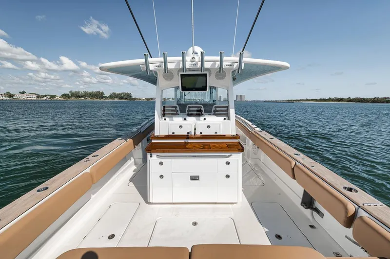 Slide: The Image of 2022 HCB Lujo boat interior with seating and helm, cruising on a sunny day. - 27